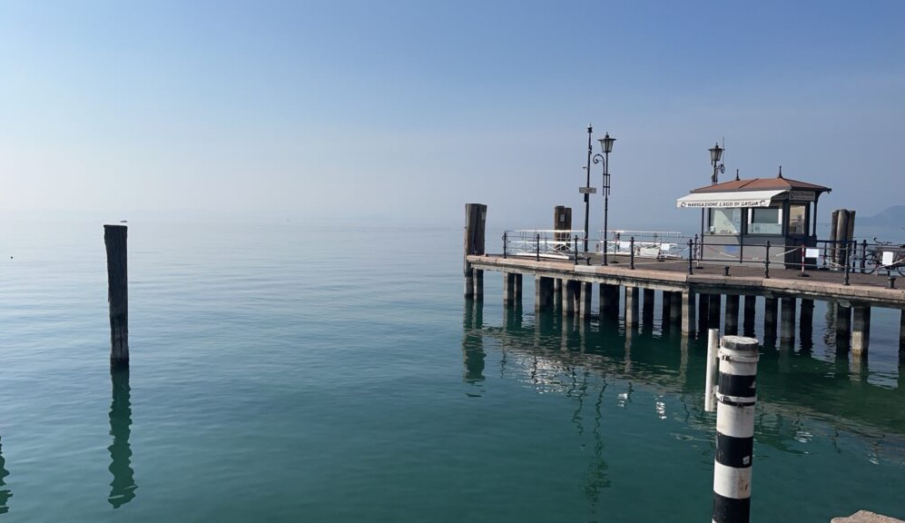 晴れの日のガルダ湖の写真。湖から空にかけてブルーを基調としたグラデーションが美しい。